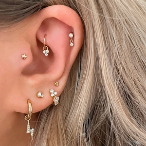 Macro shot of S925 silver gold-plated cartilage ear cuff set with lightning and star charms