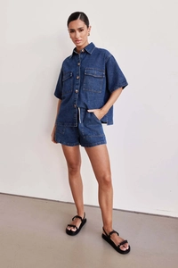 Detail of dark blue denim shirt with dual chest pockets and fine stitching texture