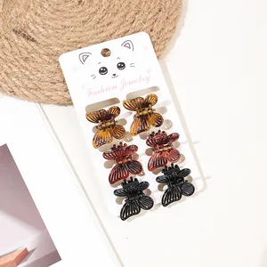 Set of 6 mini butterfly hair claws in amber, burgundy, and black on a gift card