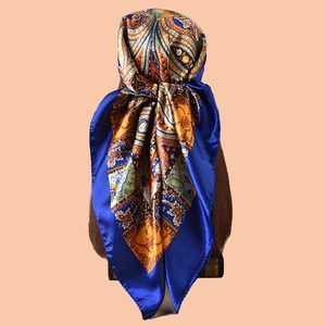 Close-up of royal blue and orange paisley silk-feel scarf draped on a mannequin