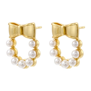 Detail shot of golden bow wreath earrings with white pearls on a clean white background