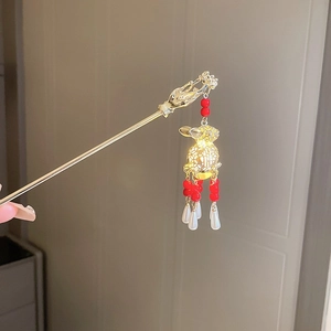 Détail d'un pic à cheveux doré avec fleur tenue et pendentif lanterne de lapin