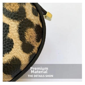 Detailed macro view of leopard print textured leather and golden metallic zipper hardware