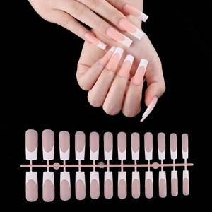 Macro detail of 24pcs long coffin French tip press-on nails in nude and white finish