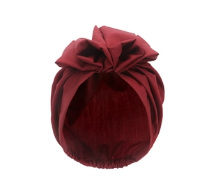 Close-up of wine red turban hat featuring pleated floral design and elastic band