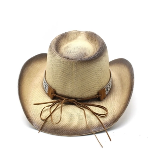 Detail of summer straw cowboy hat with ethnic embroidery and brown leather cord