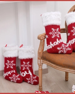 Close-up of red knitted Christmas stockings with plush white faux fur and festive embroidery