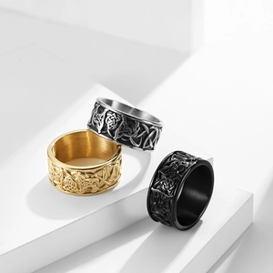 Three Celtic knot rings in gold, silver, and black finish on white geometric stands