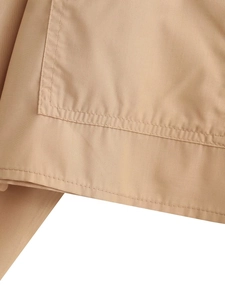 Gros plan d'une chemise courte kaki montrant le tissu tissé dense et les détails de surpiqûres