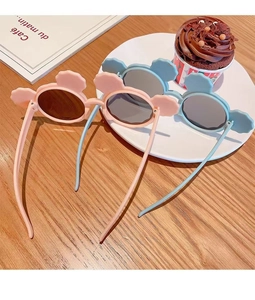 Detailed view of cute cartoon bear ear sunglasses for kids in pink and blue colors.