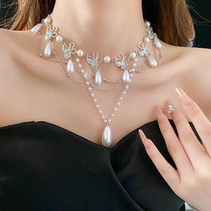 Close-up of multilayer butterfly necklace with white pearls and sparkling rhinestones