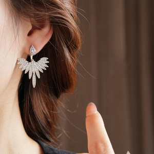 Macro shot of silver sterling leaf earrings with sparkling cubic zirconia on model