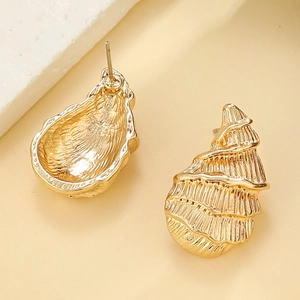 Macro shot of golden sea shell earrings with detailed spiral texture and metallic finish