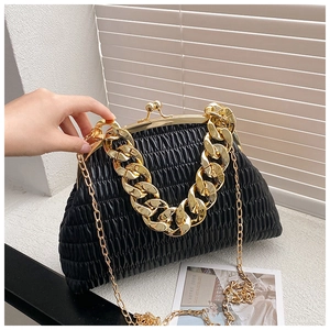 Detail of black pleated shell bag with chunky gold chain strap and metal clasp closure