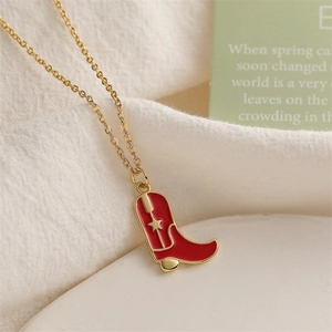 Close-up of gold necklace with a red and gold cowboy boot pendant and star detail