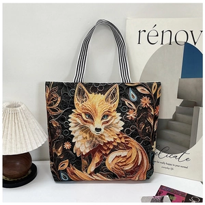 Macro detail of intricate golden fox embroidery and floral patterns on black canvas tote