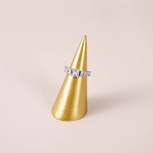 Silver row ring with square zircons on gold cone stand with beige background