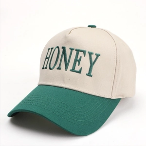 Close-up of the HONEY letter embroidery on this beige and green cotton baseball cap