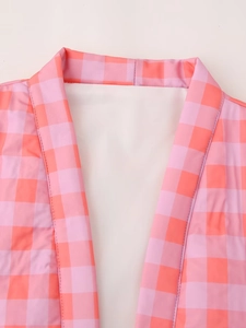Detail of pink and orange plaid collar and stitching on a casual sleeveless vest
