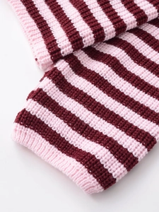Détail du tricot rayé rose et bordeaux avec poignets côtelés et texture douce