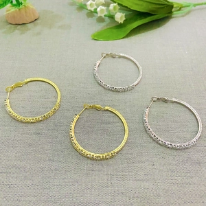 Detailed macro view of gold and silver hoop earrings with pave cubic zirconia stones