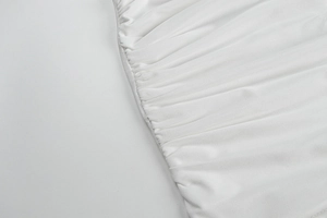 Détail de la texture du tissu blanc froncé et du design plissé sur une robe ajustée