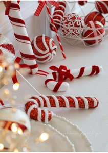 Detail of red and white foam candy cane ornaments with glitter and velvet textures