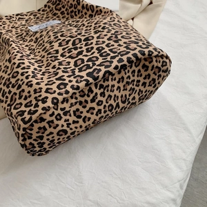Macro detail of leopard print canvas tote bag showing side seams and base stitching