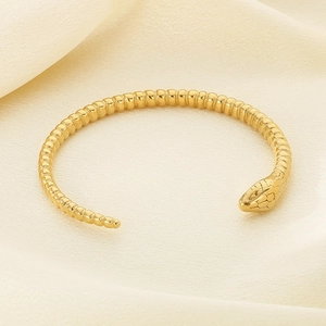 Macro shot of gold snake-head bracelet showing intricate scale texture and craftsmanship