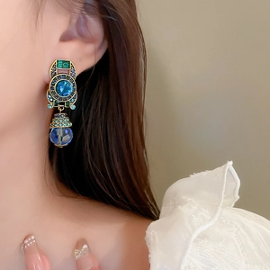 Detail of vintage French style drop earring with blue crystal and gold finish