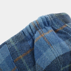 Detailed macro view of the blue checkered wool fabric and elastic band on the newsboy cap