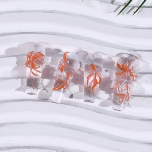 Detail of clear press-on nails with 3D orange koi fish and floral embossed patterns