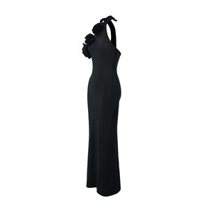 Close-up of elegant 3D floral decoration on the halter neck of a slim black maxi dress