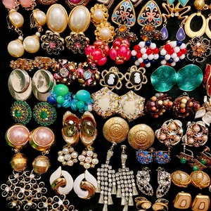 Collection of vintage gold-tone earrings with pearls and rhinestones on black velvet