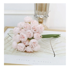 Detailed close-up of pink artificial tea rose bouquet with realistic petals and green stems