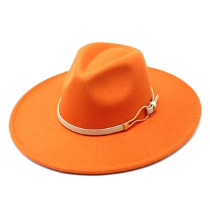 Detail of orange wool fedora with wide brim, beige band, and golden metal buckle