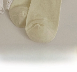 Macro detail of beige knit sock showing reinforced toe and seamless stitching