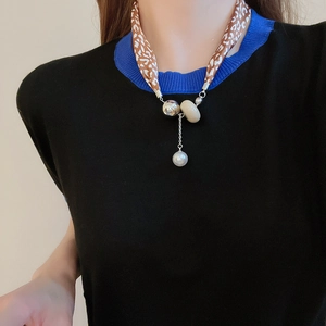 Détail du collier foulard en soie léopard avec perles argentées et pendentif perle