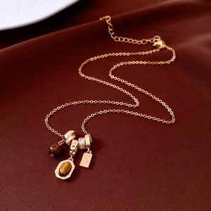 Detail of tiger eye pendant necklace on dark red silk background with golden chain