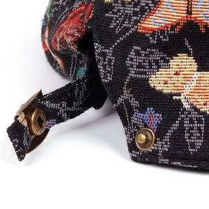 Détail de la casquette jacquard vintage avec motifs papillons et boucle en métal
