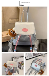 Close-up of silver mini backpack with pink drawstring and brown plush doll pendant