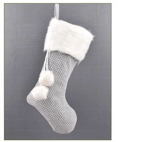 Détail d'une chaussette de Noël en tricot gris avec revers en fausse fourrure blanche
