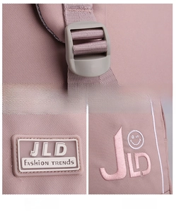 Detail of pink backpack showing adjustable shoulder straps and JLD brand embroidery