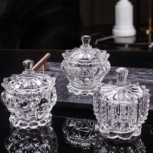 Three modern clear glass candy jars with lids set on a black marble tabletop for decor