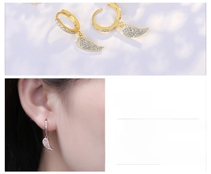 Close-up of heart-shaped wing earrings with micro-inlaid cubic zirconia and gold plating