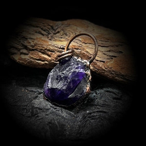 Dettaglio del ciondolo in cristallo viola grezzo con avvolgimento in rame artigianale