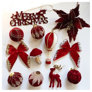 Flat lay of velvet burgundy Christmas ornaments with glitter details and festive signs