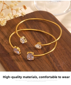 Close-up of golden stainless steel bracelets with heart and square cubic zirconia stones