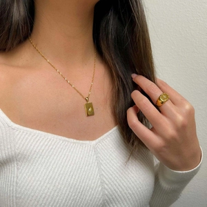 Detail of 18K gold plated stainless steel rectangle star pendant and signet ring on model