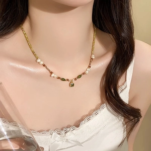 Detail of 18k gold plated necklace with square green gemstone and freshwater pearls